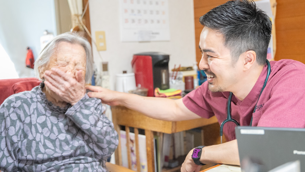 患者さんに笑顔で寄り添いながら在宅診療を行う菅原医師(悠翔会在宅クリニックもりや)